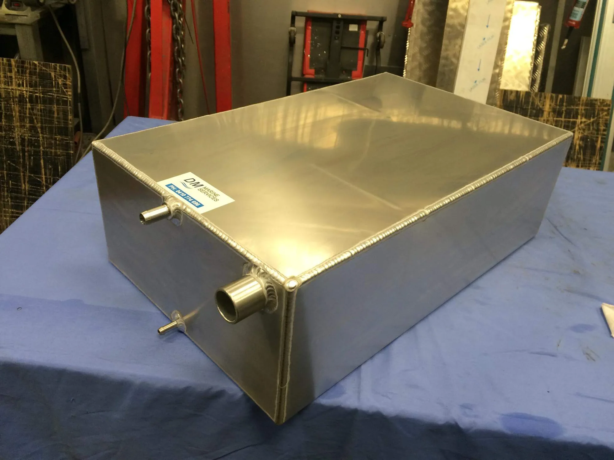 A custom welded aluminium fuel tank on the bench in the DM Marine workshop
