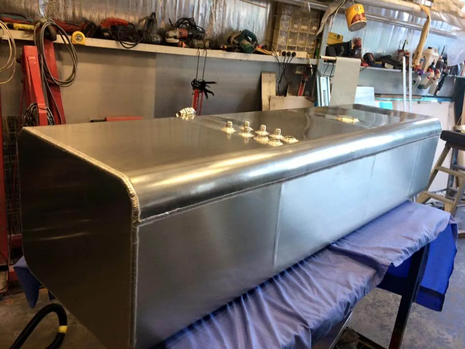 A large welded aluminium fuel tank finished on the workshop bench